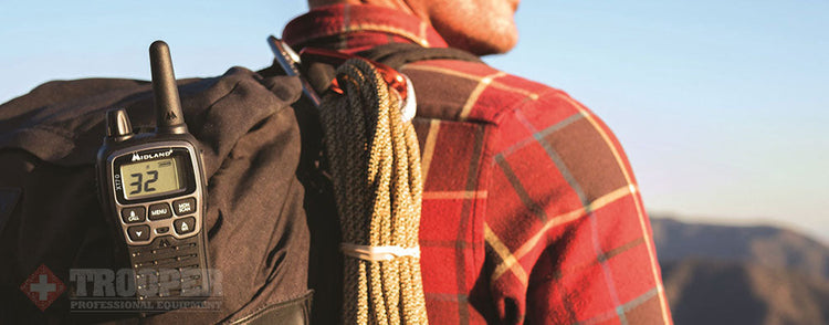 Mann mit einem am Rucksack befestigten Walkie-Talkie.