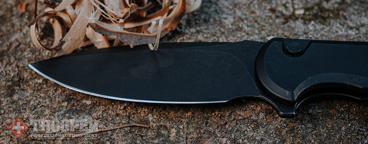 Schwarzes Klappmesser liegt auf einem Stein