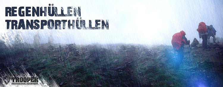 Wanderer im Regen mit Rucksäcken, geschützt durch Regenhüllen