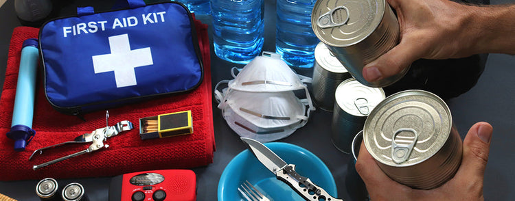 Verschiedene Bestandteile eines Survival-Kits wie Dosen, ein Erste-Hilfe-Set, Masken, Streichhölzer und vieles mehr.