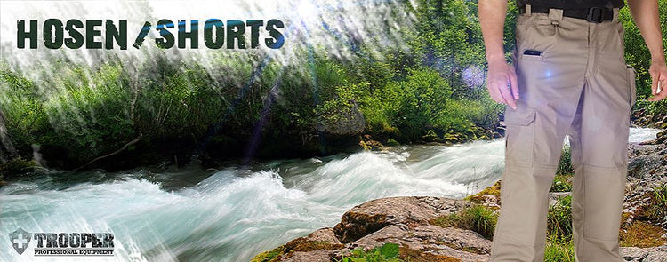 Person mit Outdoor-Hose steht am Fluss